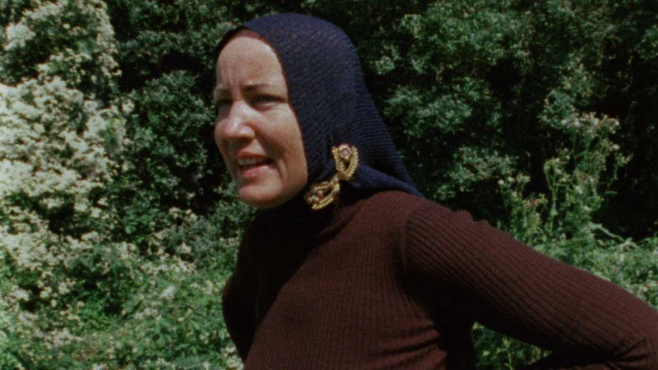a woman with a knit head scarf standing outside